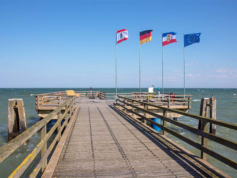 Fahnen wehen auf der Seebrücke im Ostseebad Dahme in Schleswig-Holstein