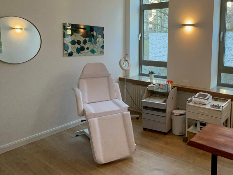 Behandlungsraum für Faltenbehandlung mit Praxisstuhl, Spiegel, Fenster und dezentem Licht – sauber, funktional und einladend.