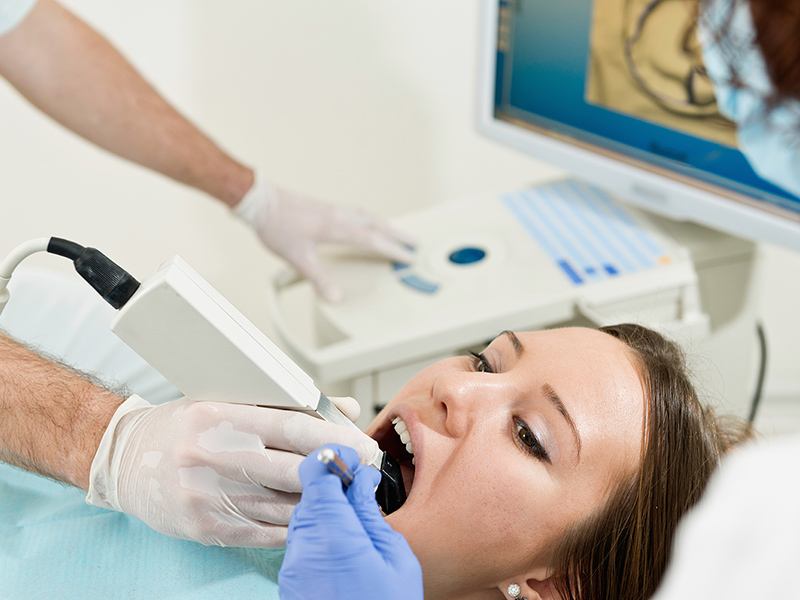 Zahnarzt, der die Zähne des Patienten mit CEREC® Scanner scannt